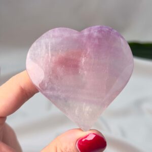 Fluorit Candy Hjerte Krystal Sten i hånd på hvid baggrund