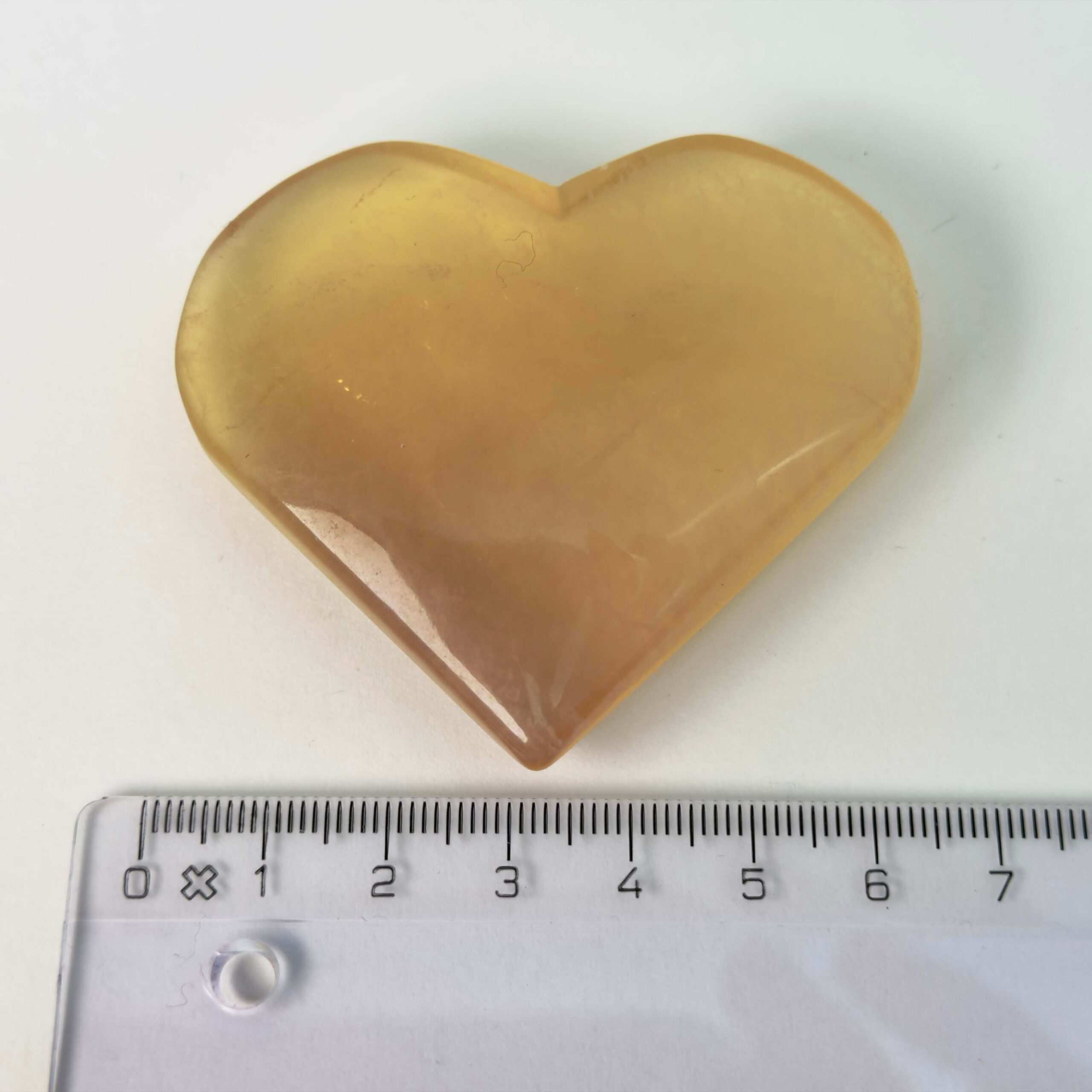 Fluorit Candy Hjerte Krystal Sten med lineal på hvid baggrund