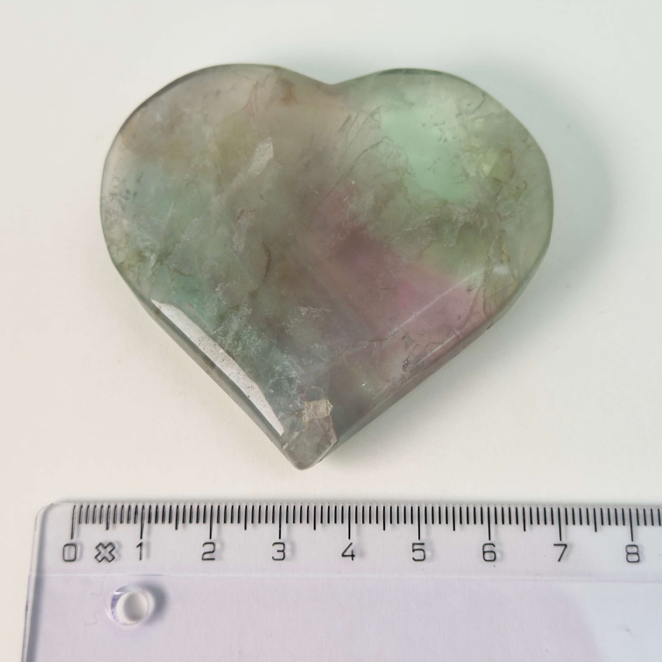 Fluorit Candy Hjerte Krystal Sten med lineal på hvid baggrund