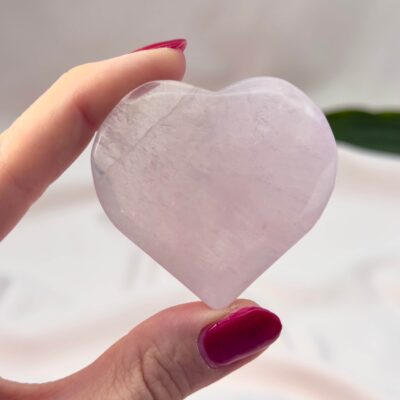 Fluorit Candy Hjerte Krystal Sten i hånd på hvid baggrund