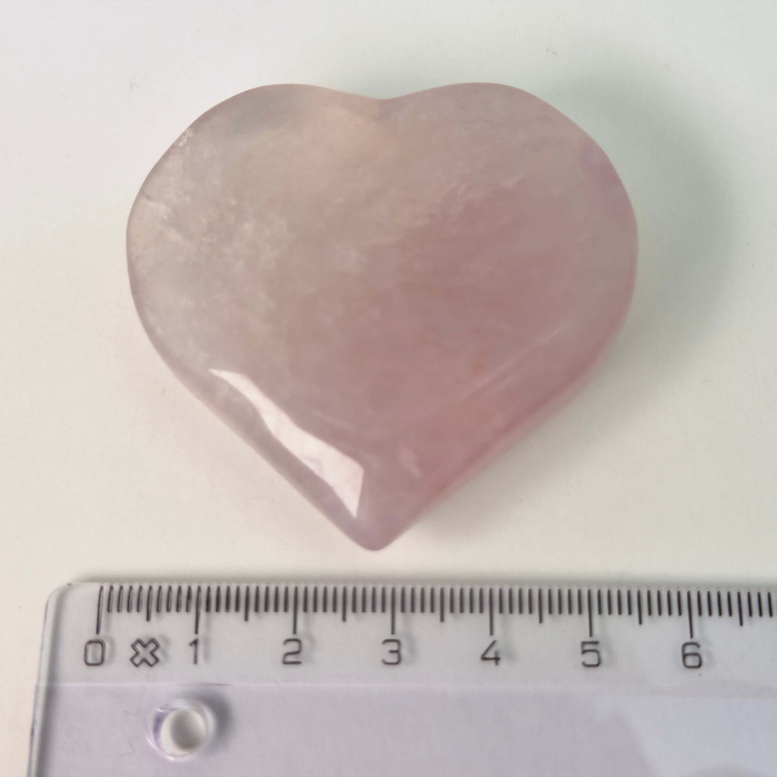 Fluorit Candy Hjerte Krystal Sten med lineal på hvid baggrund
