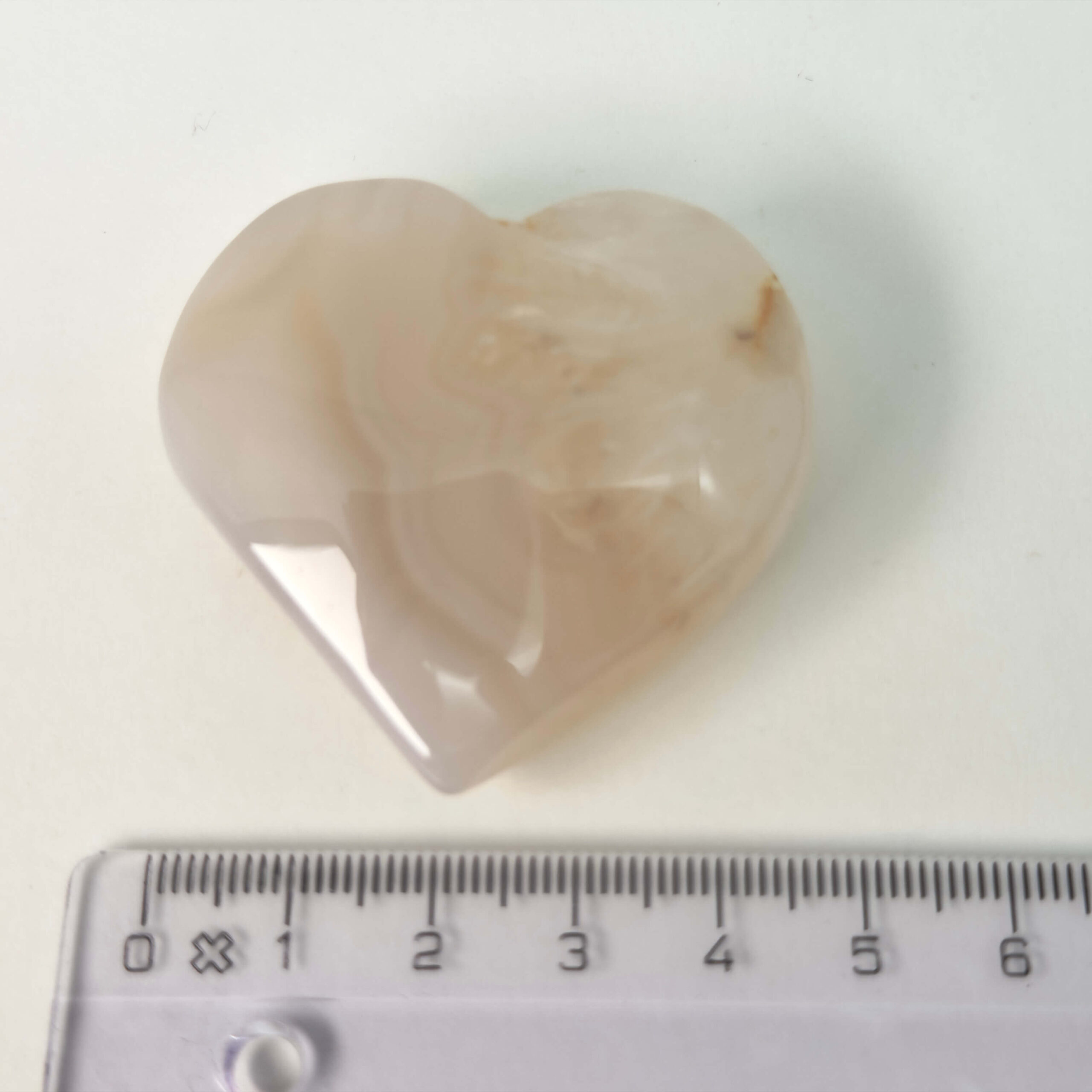 Fluorit Candy Hjerte Krystal Sten med lineal på hvid baggrund