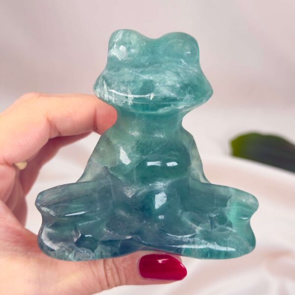 Fluorit Grøn Meditationsfrø krystal sten i hånd på hvid baggrund