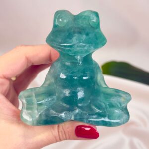 Fluorit Grøn Meditationsfrø krystal sten i hånd på hvid baggrund