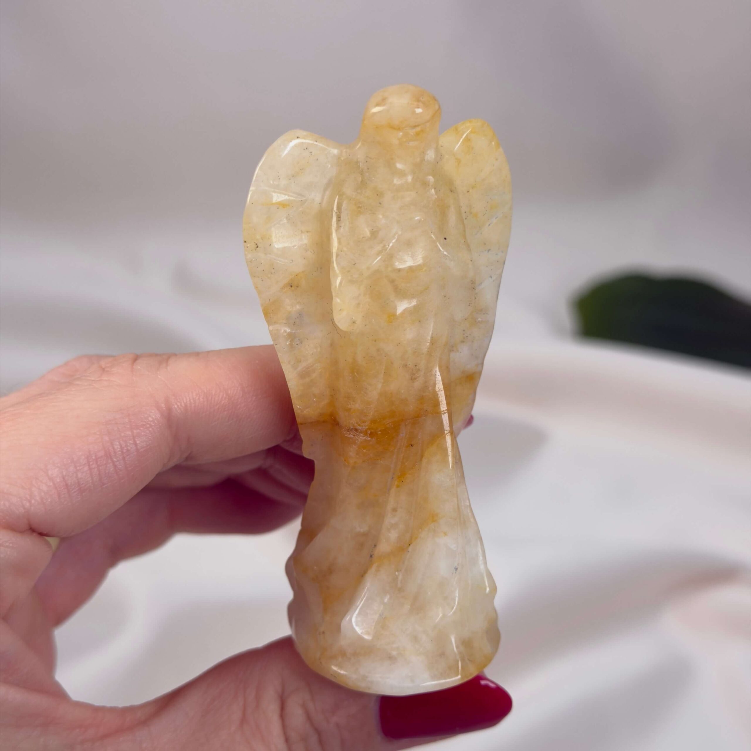 Golden Healer Engel Krystal Sten i hånd på hvid baggrund