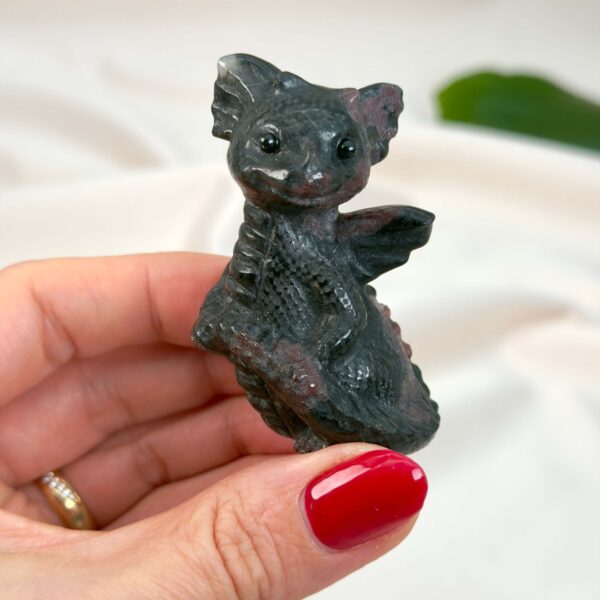 Granat Babydrage Krystal Sten i hånd på hvid baggrund