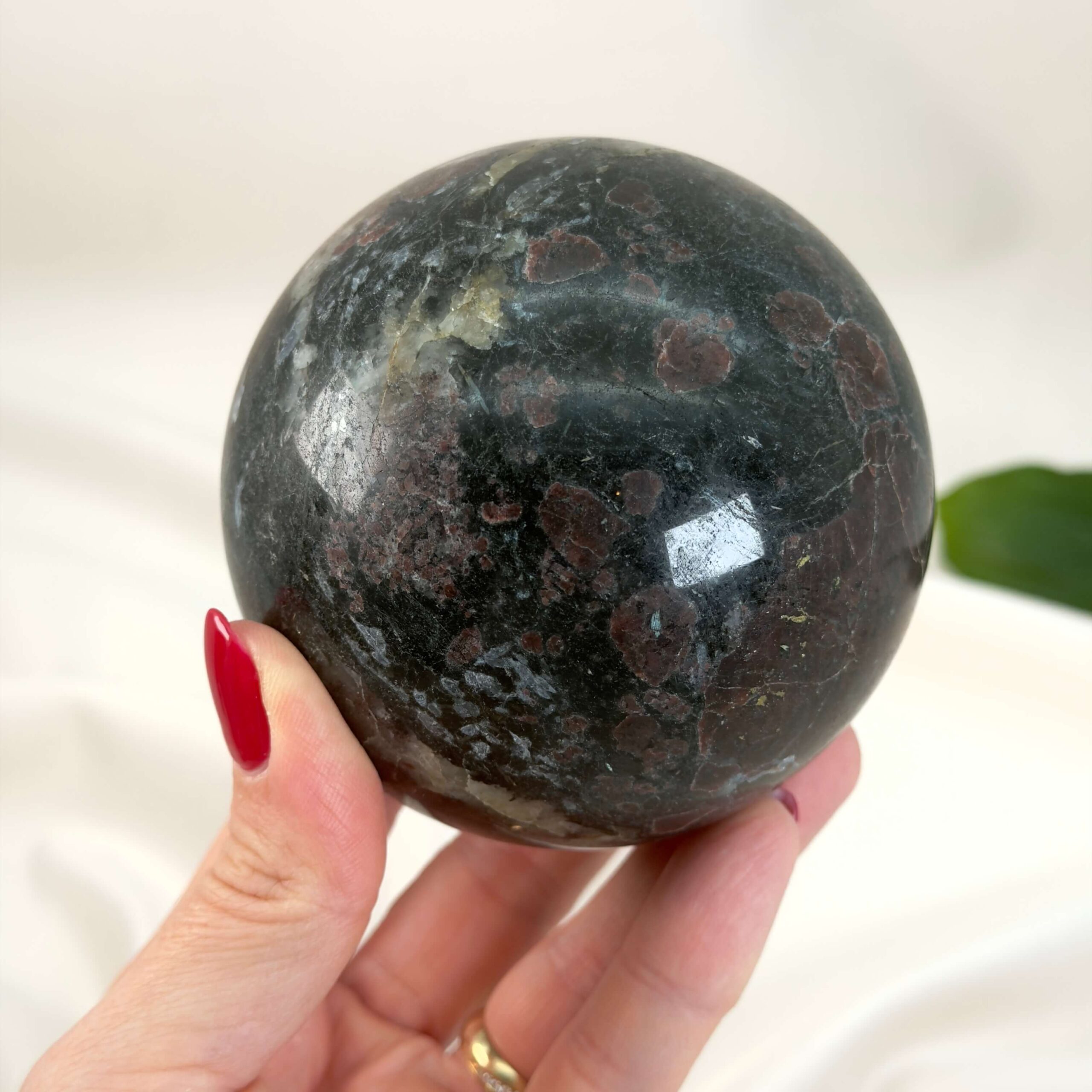 Granat Kugle krystal sten i hånd på hvid baggrund