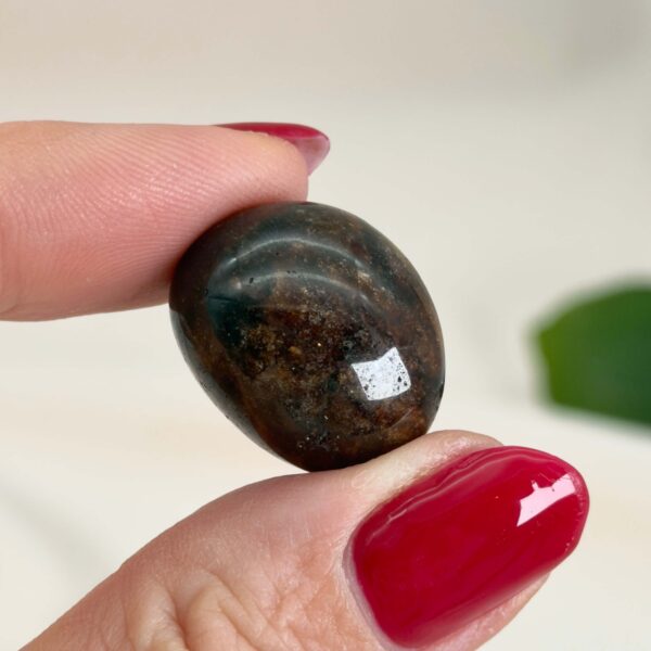 Granat Lommesten krystal sten i hånd på hvid baggrund