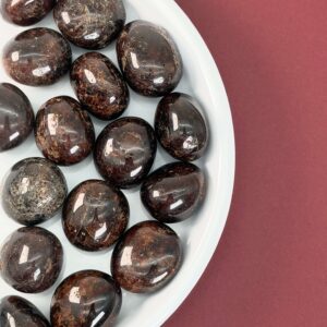 Granat Lommesten krystal sten samling på rød baggrund