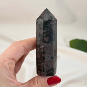 Granat Tårn krystal sten i håndpå hvid baggrund