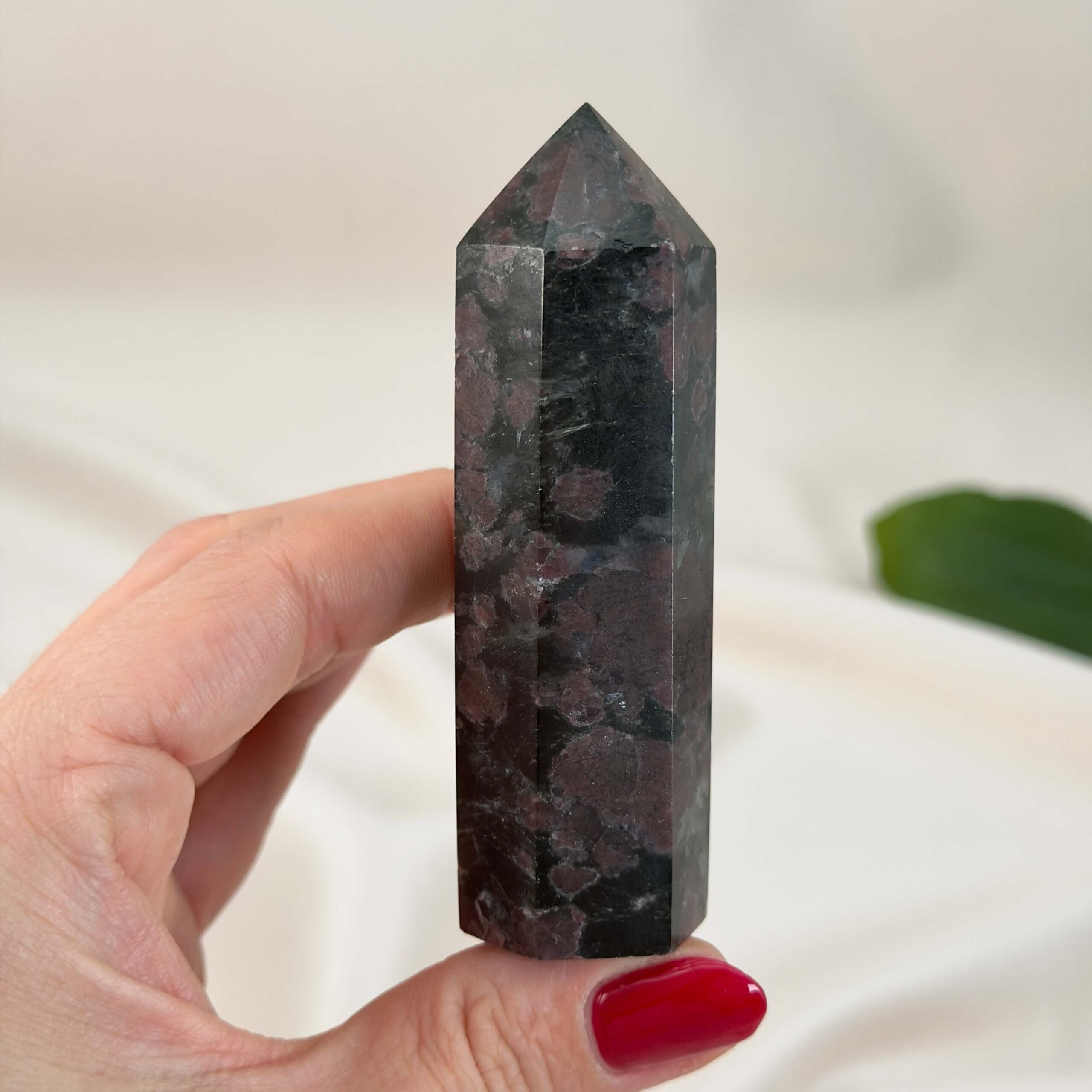 Granat Tårn krystal sten i håndpå hvid baggrund