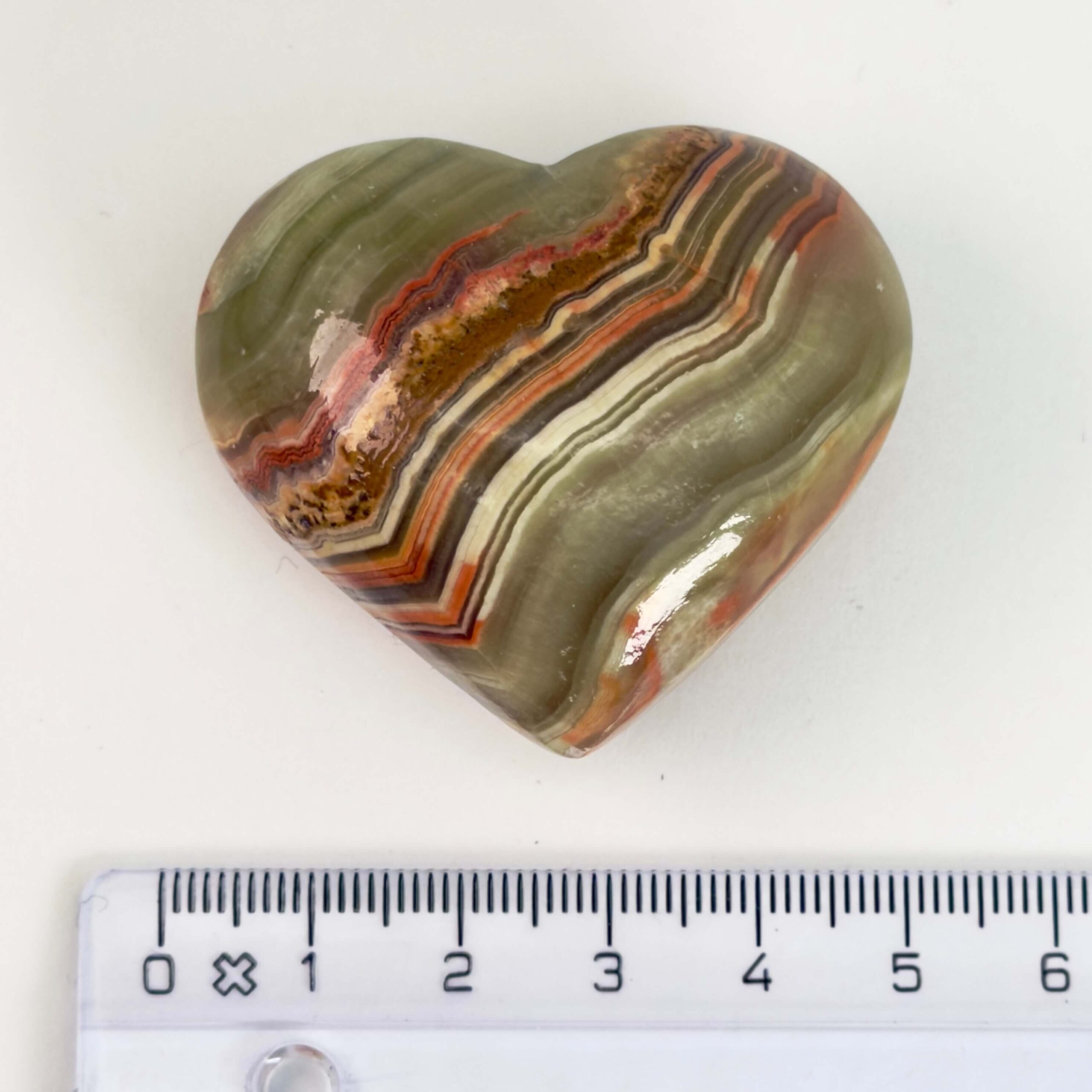 Grøn Onyx Hjerte krystal sten med lineal på hvid baggrund