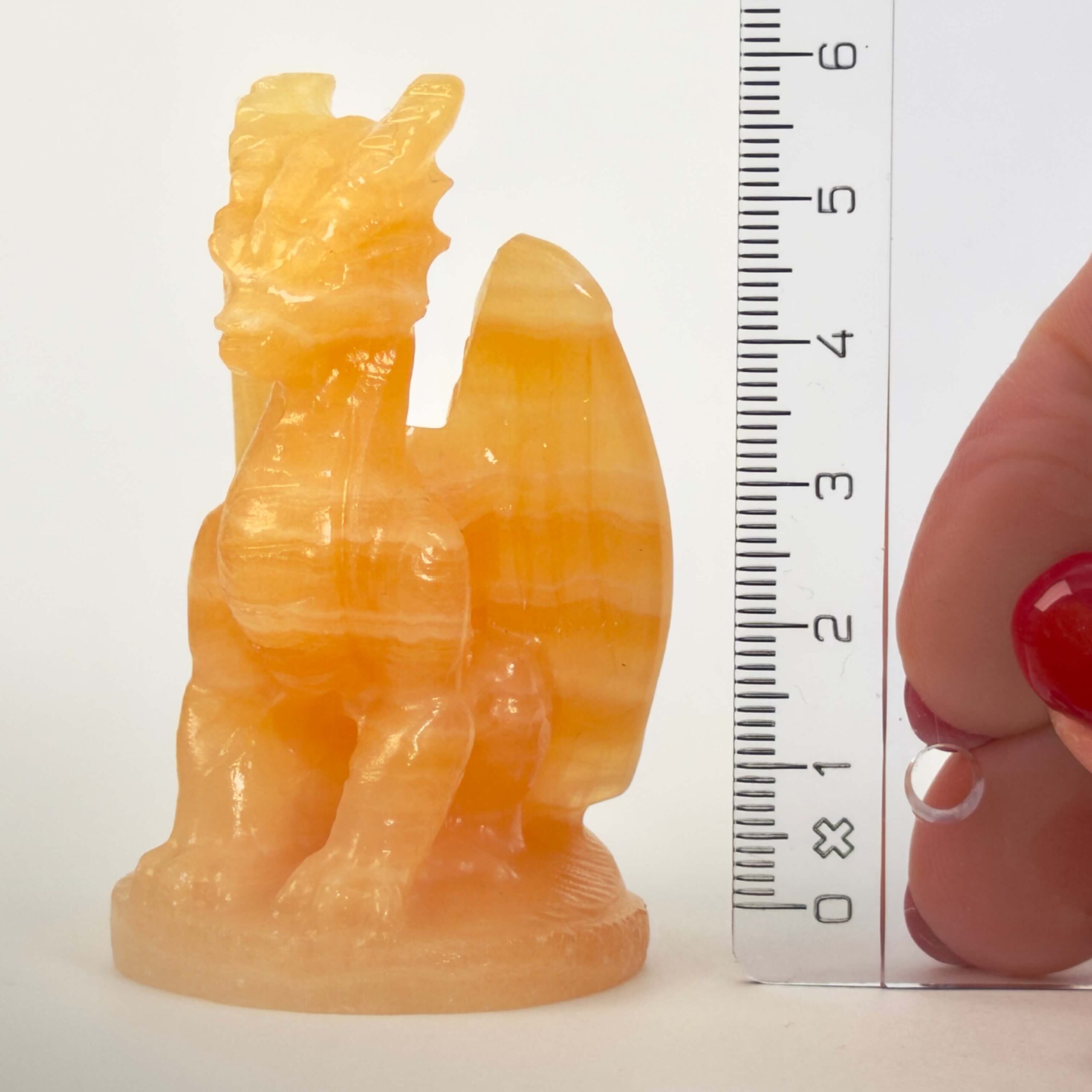 Gul Calsit Drage Krystal Sten med lineal på hvid baggrund