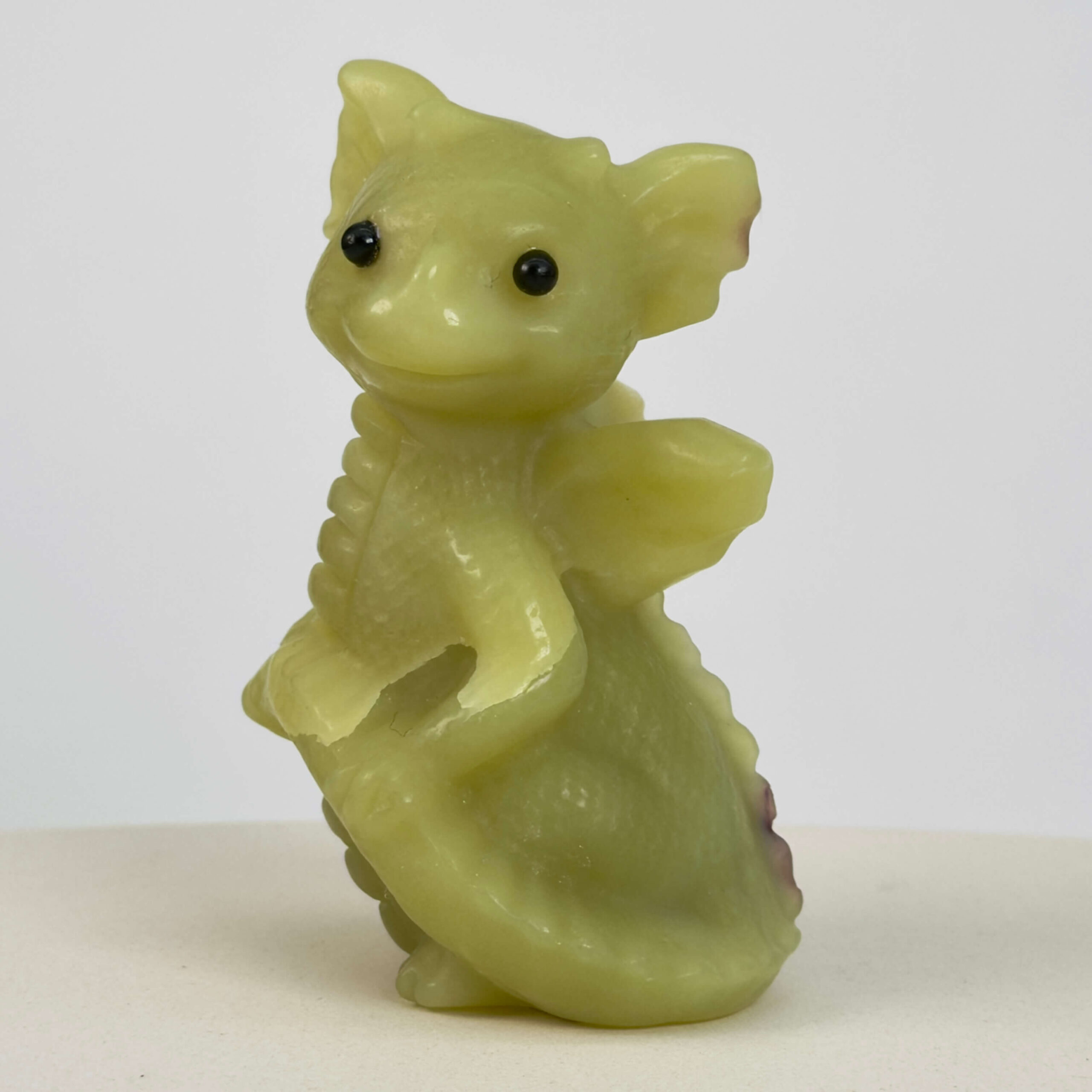 Serpentin Babydrage Krystal sten på hvid baggrund