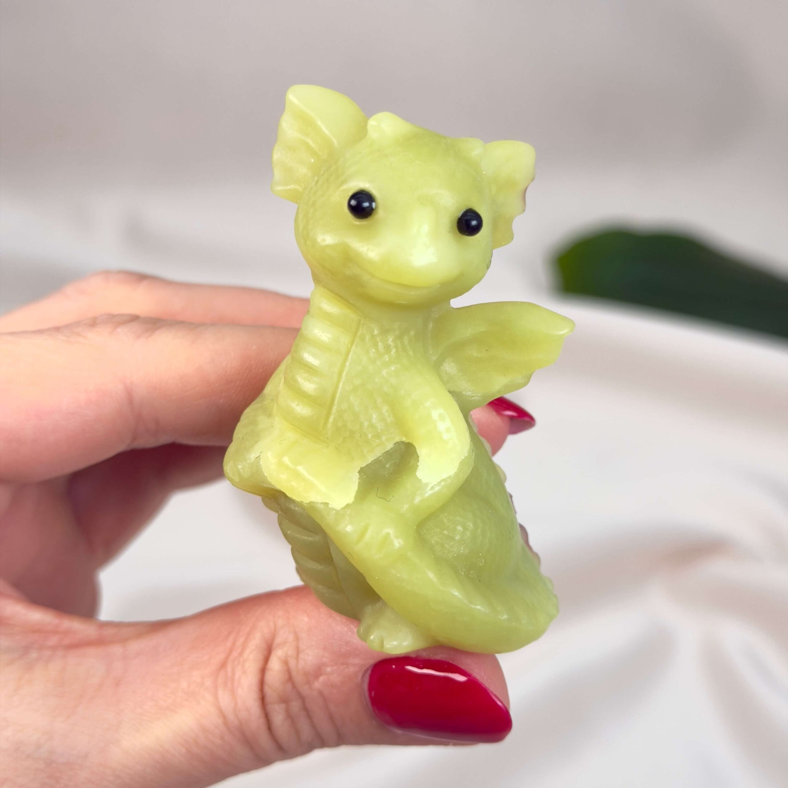 Serpentin Babydrage Krystal sten i hånd på hvid baggrund