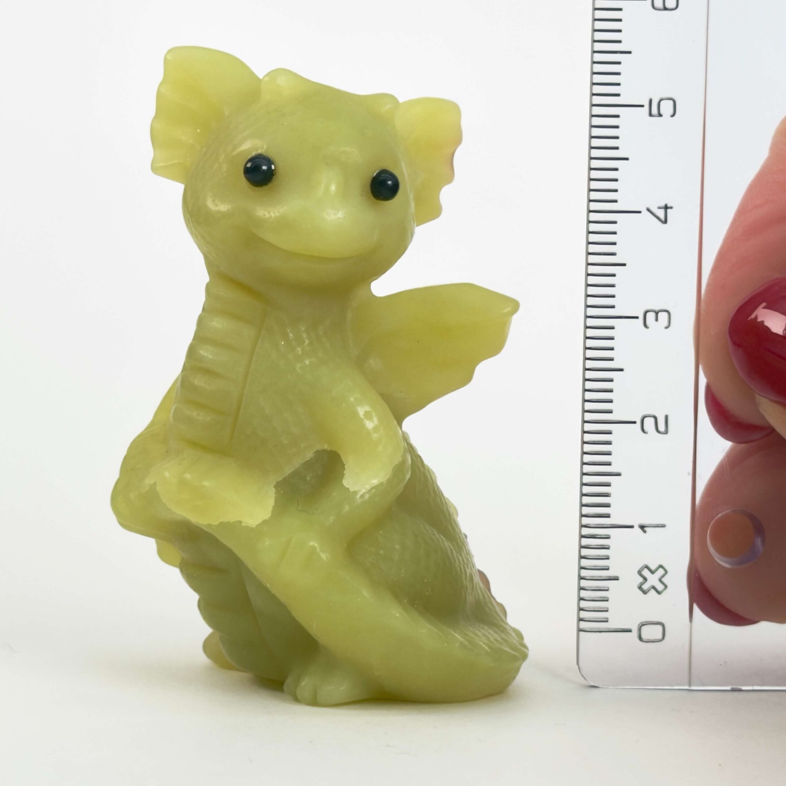 Serpentin Babydrage Krystal sten med lineal på hvid baggrund