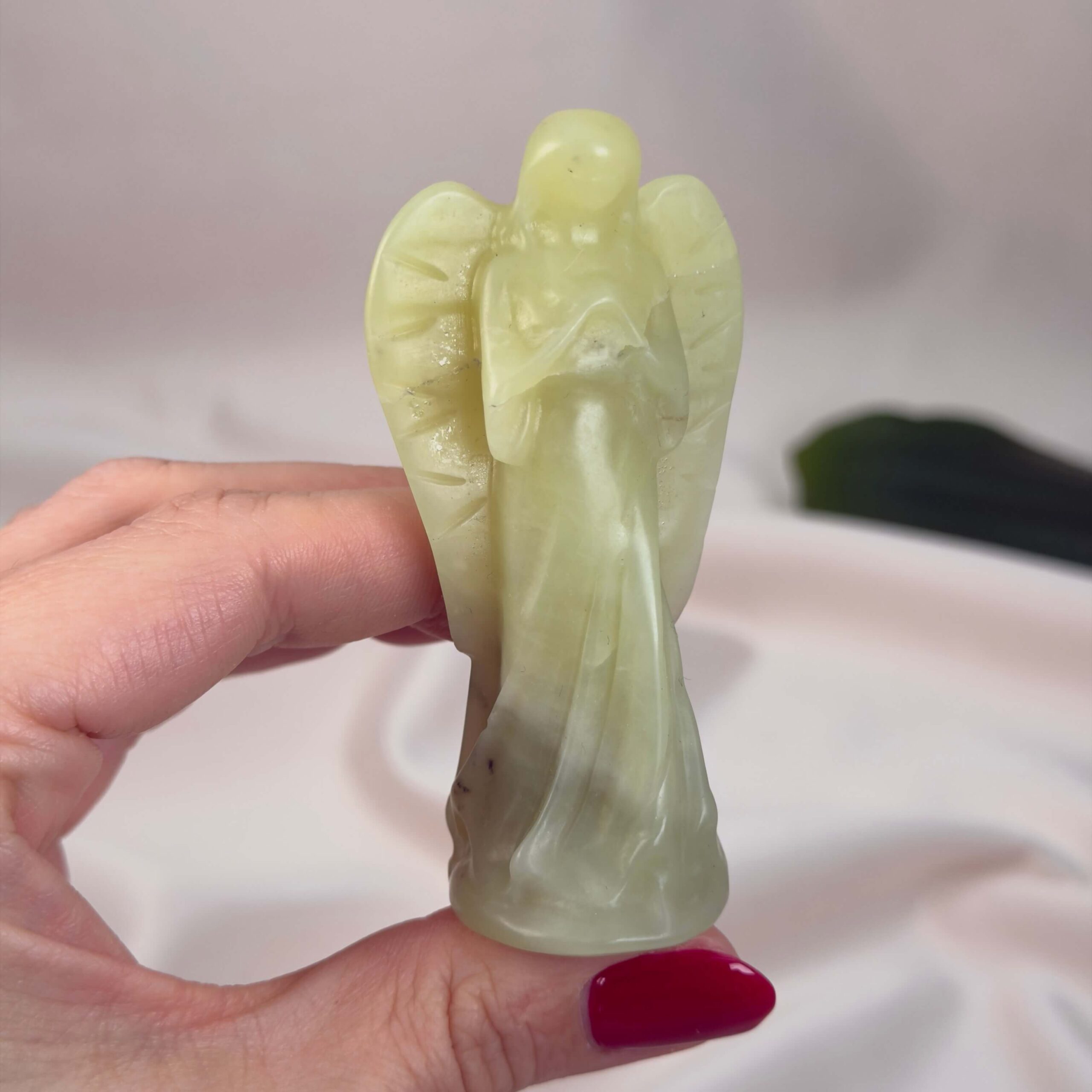 Gul Serpentin Engel krystal sten i hånd på hvid baggrund