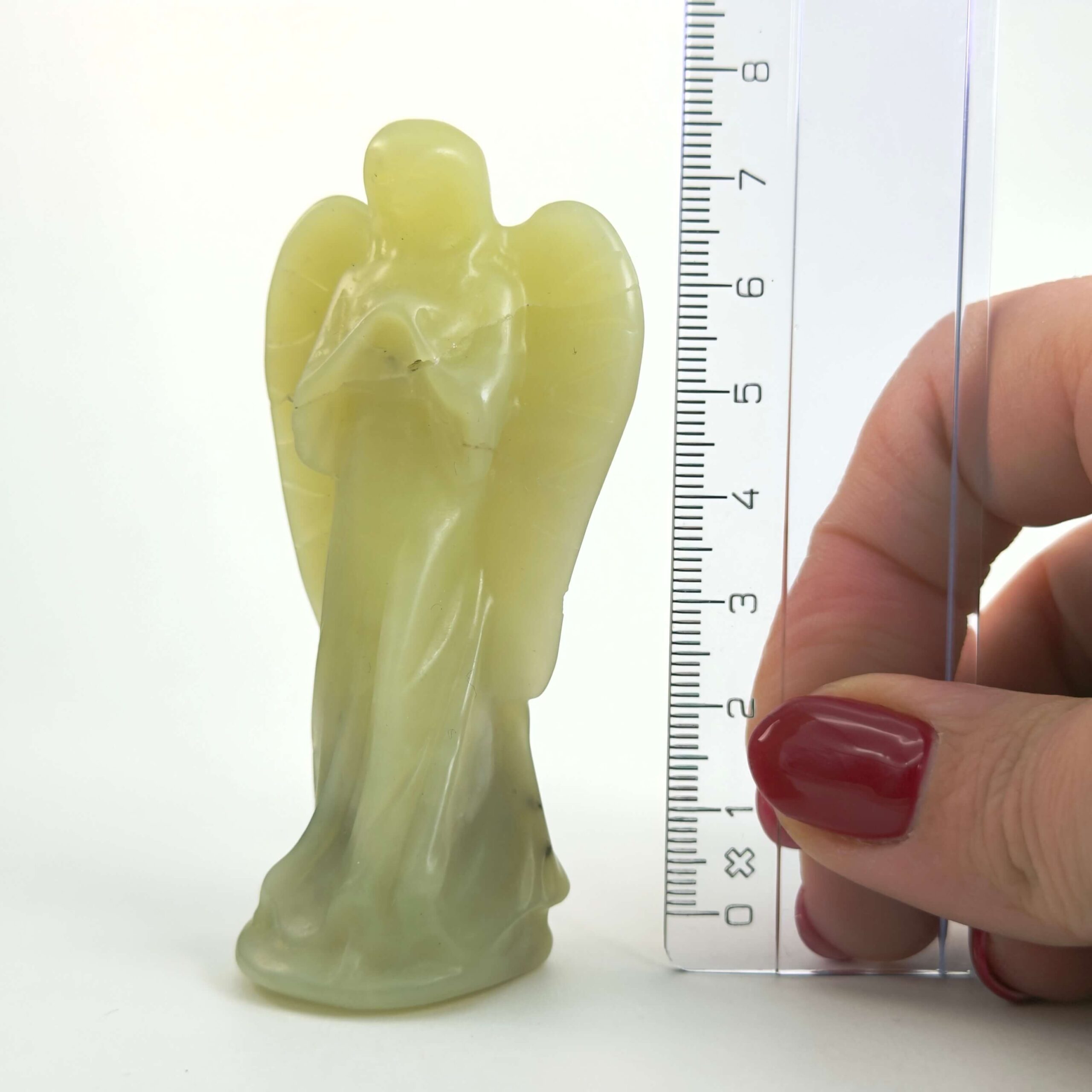 Gul Serpentin Engel krystal sten med lineal på hvid baggrund