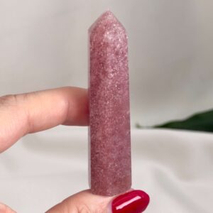 Jordbærkvarts tårn krystal sten i hånd på hvid baggrund