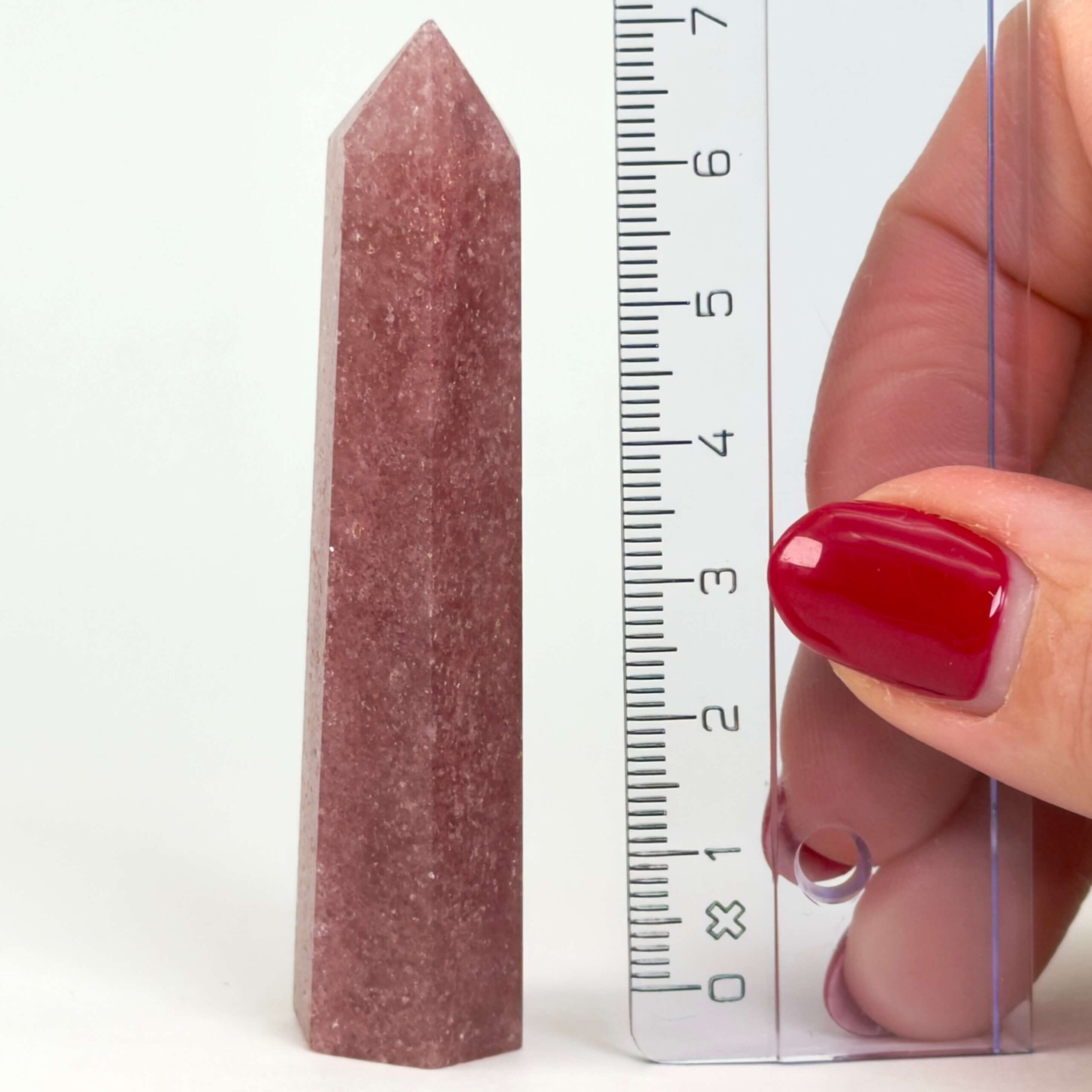 Jordbærkvarts tårn krystal sten med lineal på hvid baggrund
