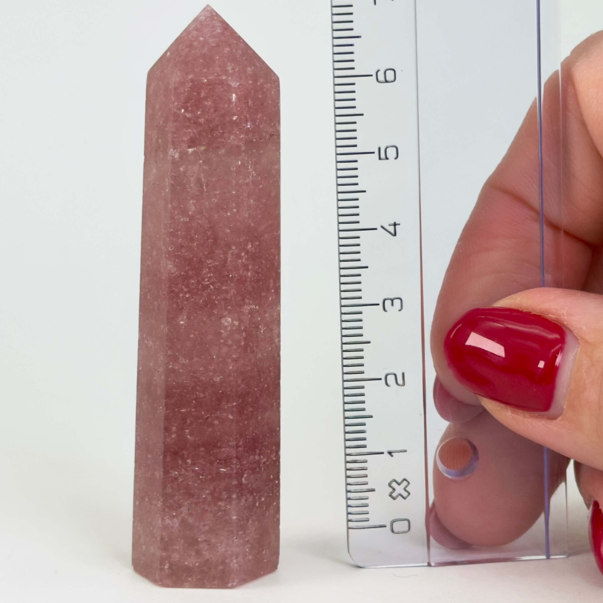 Jordbærkvarts tårn krystal sten med lineal på hvid baggrund