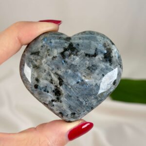 Larvikit Hjerte krystal sten i hånd på hvid baggrund