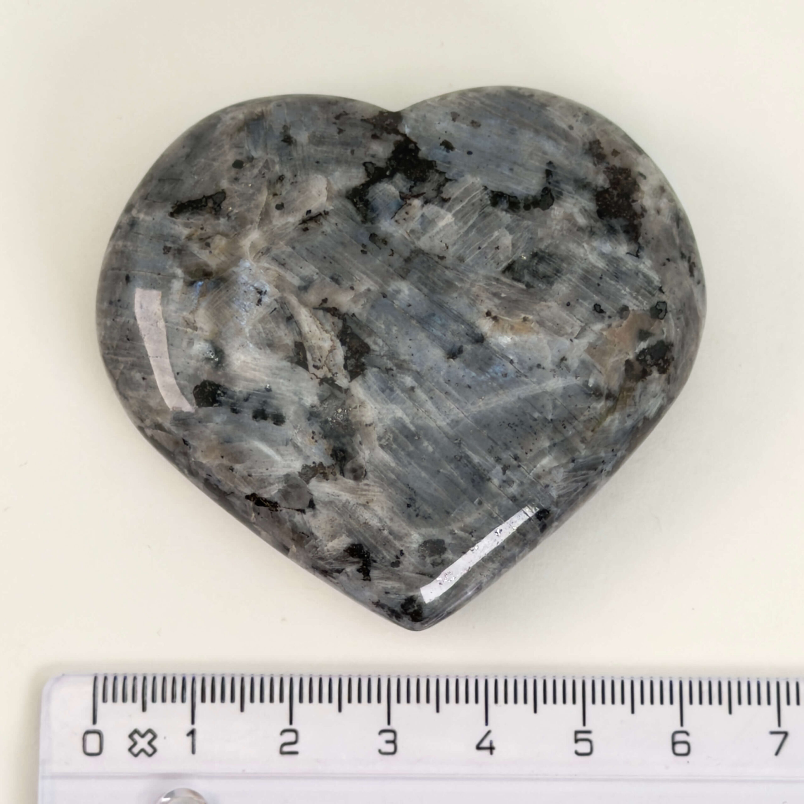 Larvikit Hjerte krystal sten med lineal på hvid baggrund