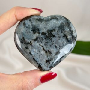 Larvikit Hjerte krystal sten i hånd på hvid baggrund