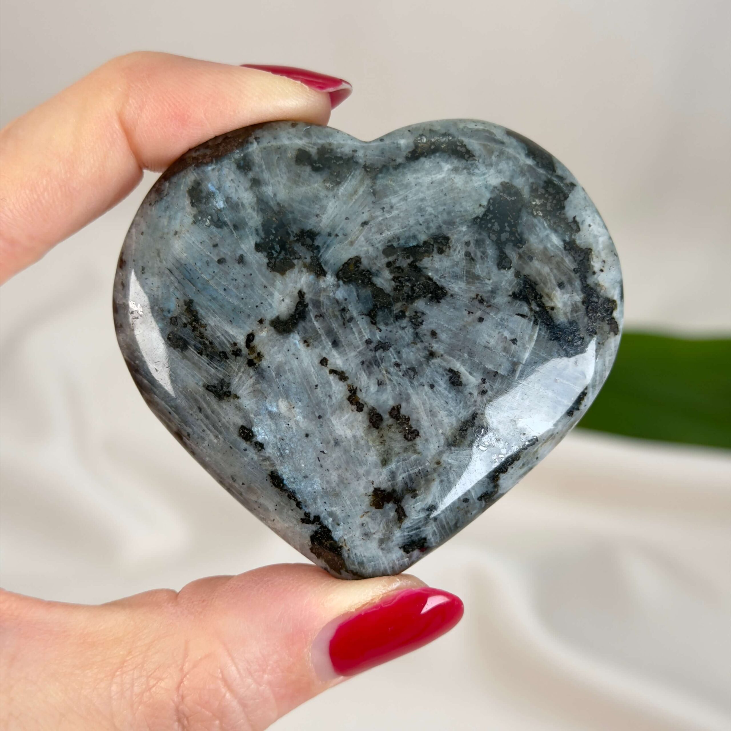 Larvikit Hjerte krystal sten i hånd på hvid baggrund