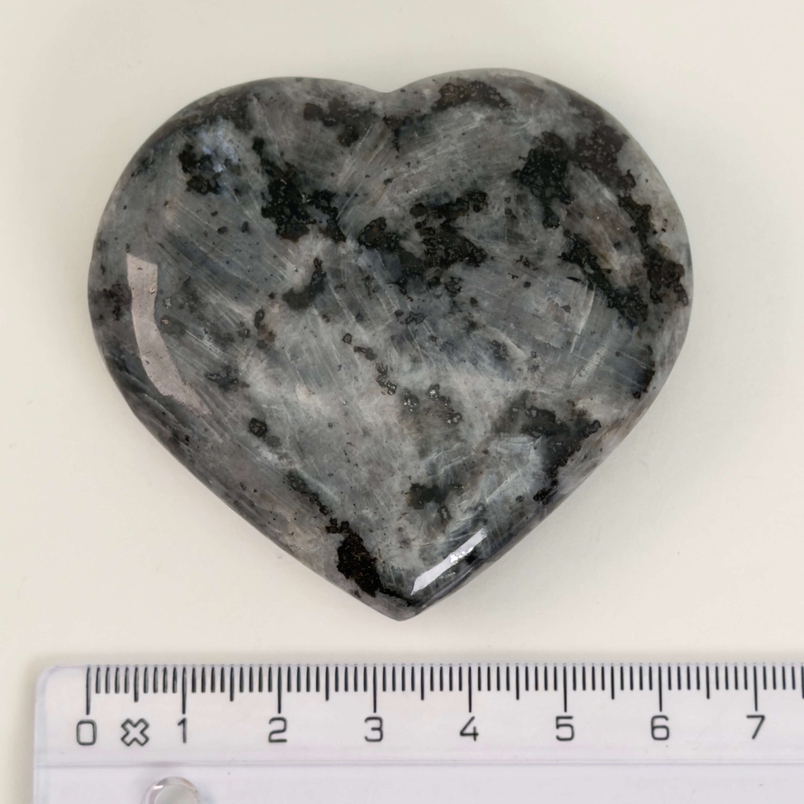 Larvikit Hjerte krystal sten med lineal på hvid baggrund