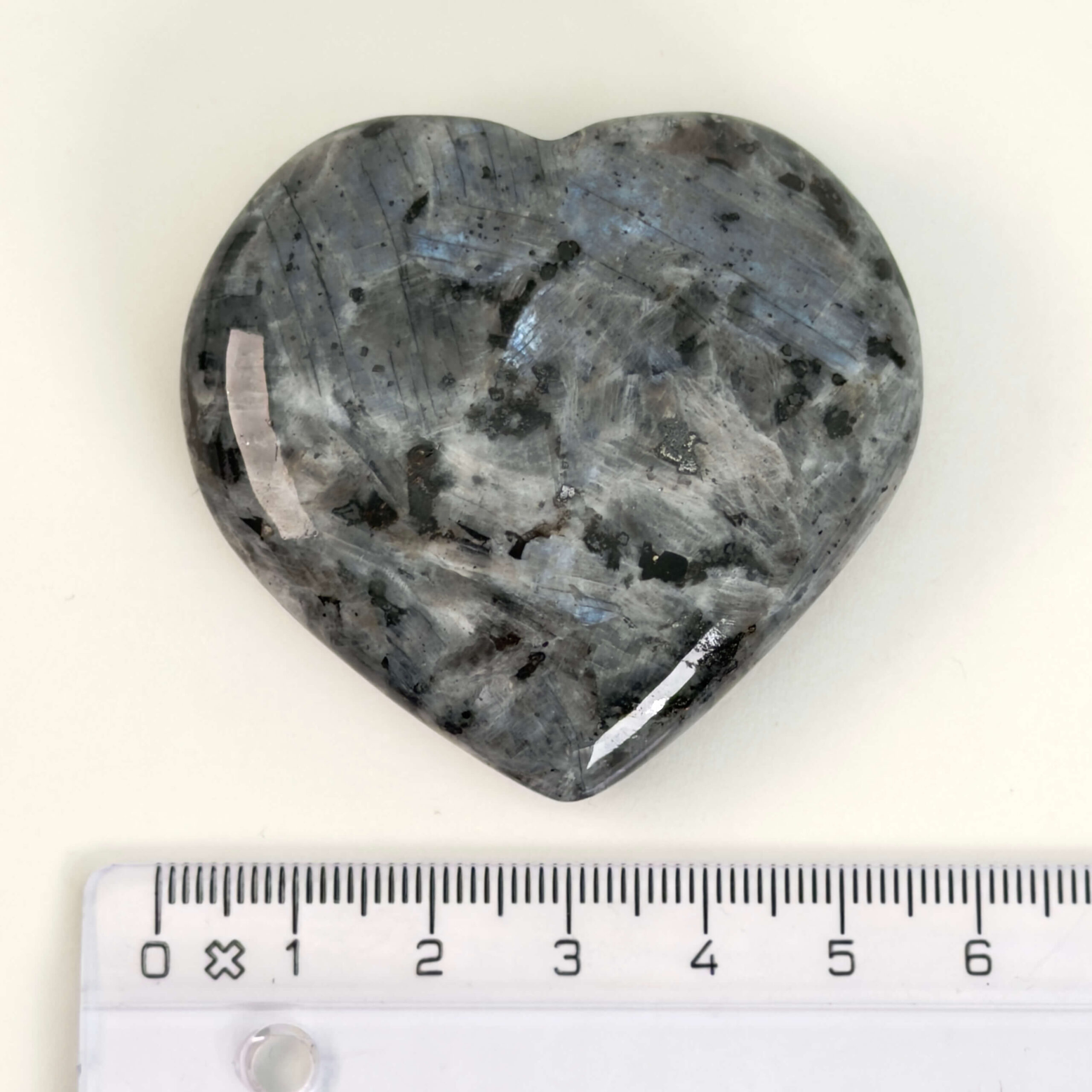 Larvikit Hjerte krystal sten med lineal på hvid baggrund