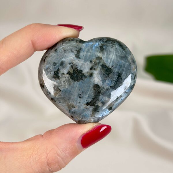 Larvikit Hjerte krystal sten i hånd på hvid baggrund