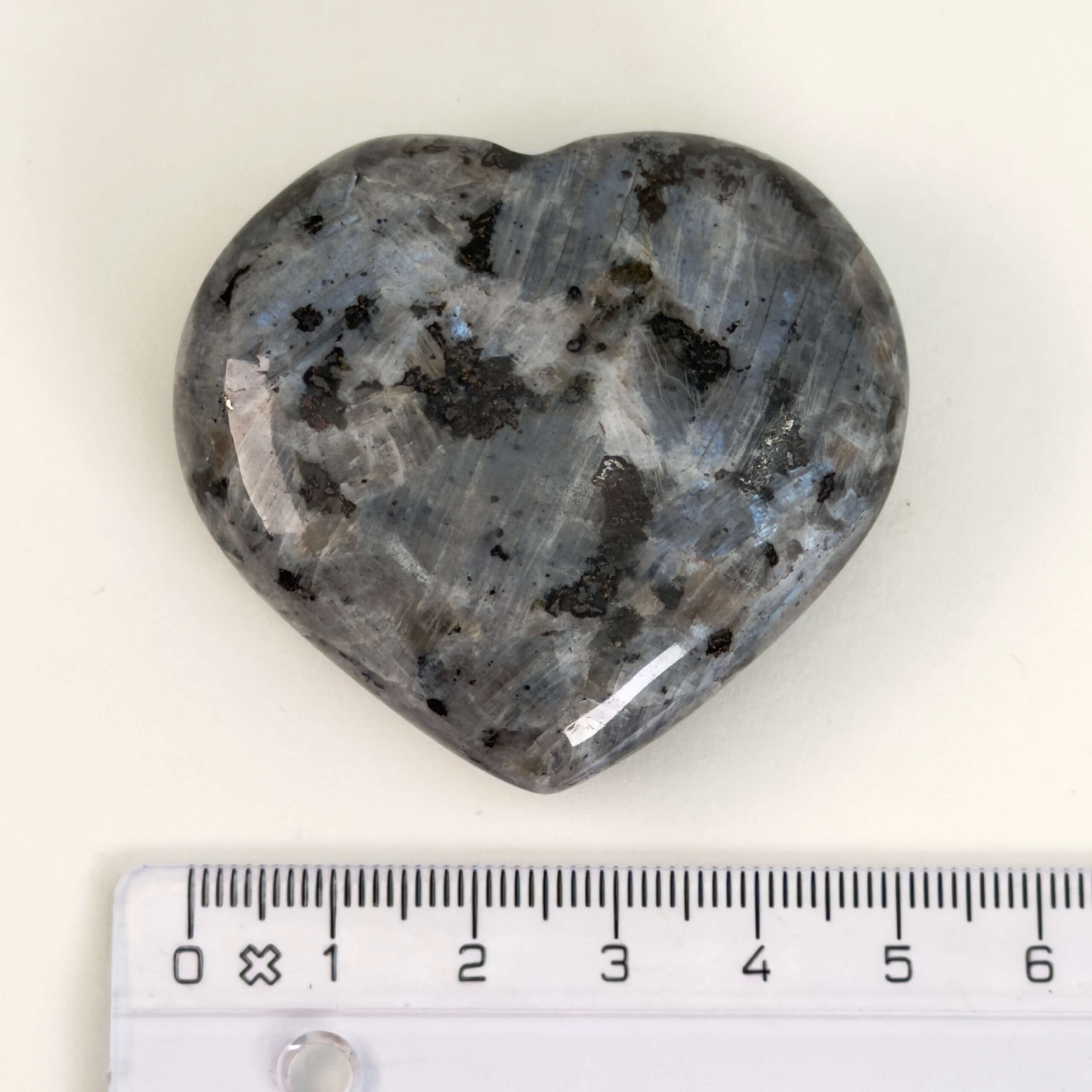 Larvikit Hjerte krystal sten med lineal på hvid baggrund