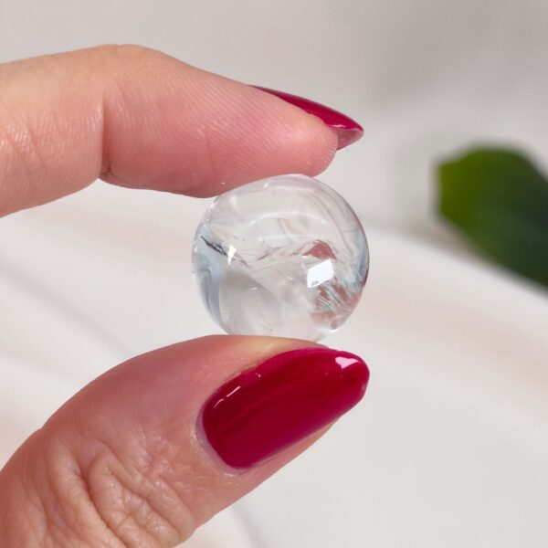 Bjergkrystal Mini Kugle krystal sten i hånd på hvid baggrund