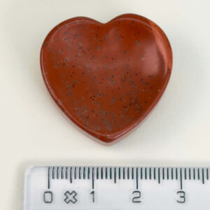 Rød Jaspis bekymringssten krystal sten med lineal på hvid baggrund