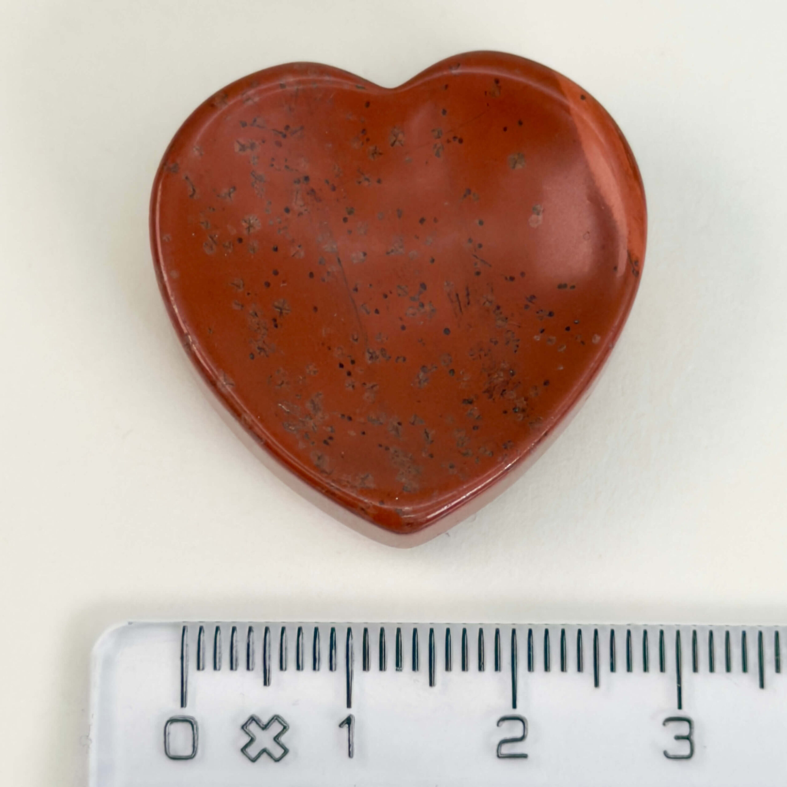 Rød Jaspis bekymringssten krystal sten med lineal på hvid baggrund
