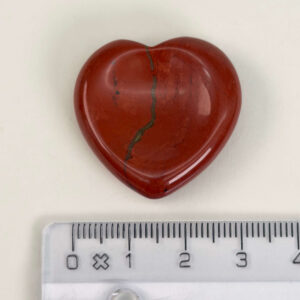 Rød Jaspis bekymringssten krystal sten med lineal på hvid baggrund
