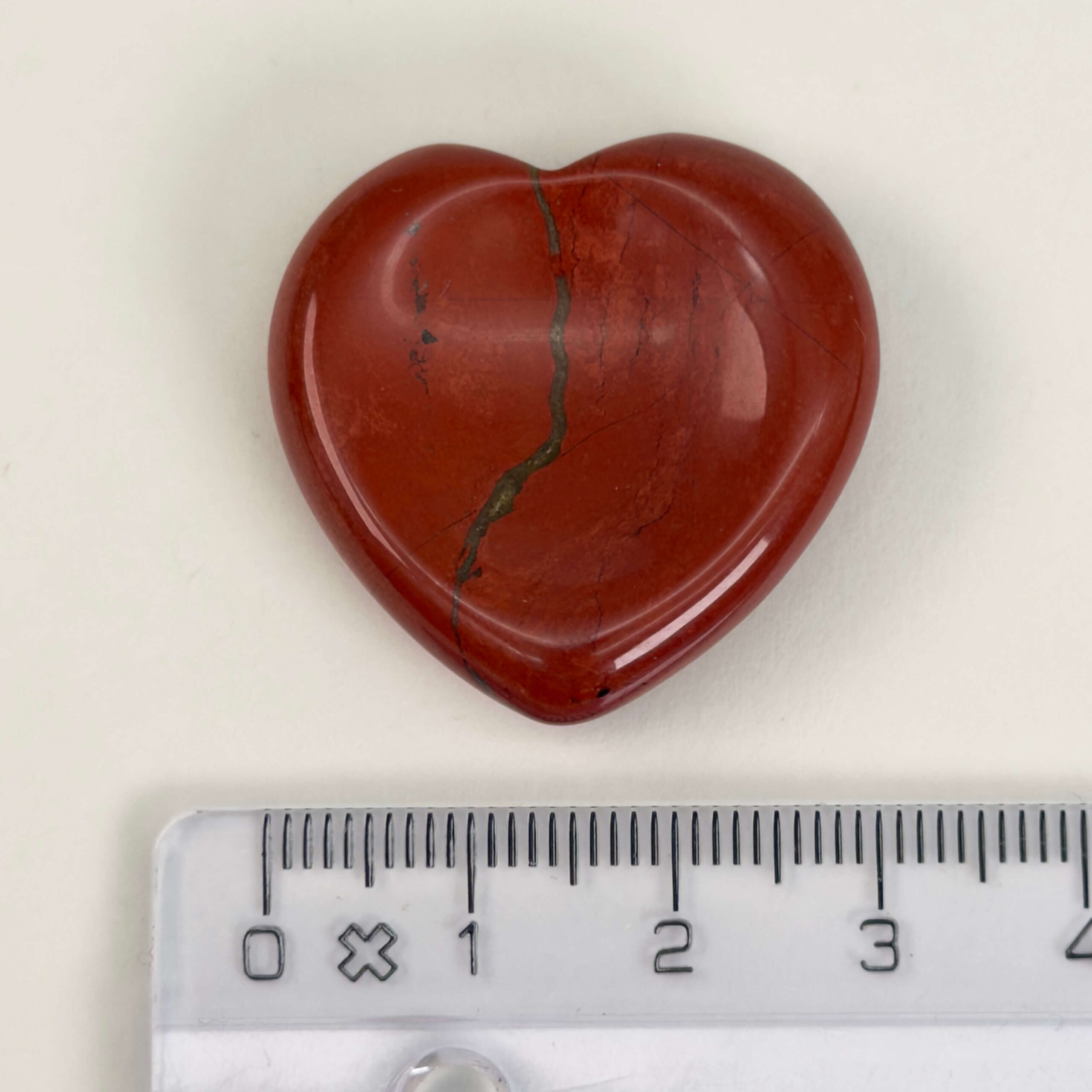 Rød Jaspis bekymringssten krystal sten med lineal på hvid baggrund