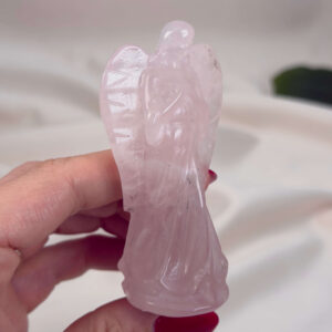 Rosakvarts Engel krystal sten i hånd på hvid baggrund