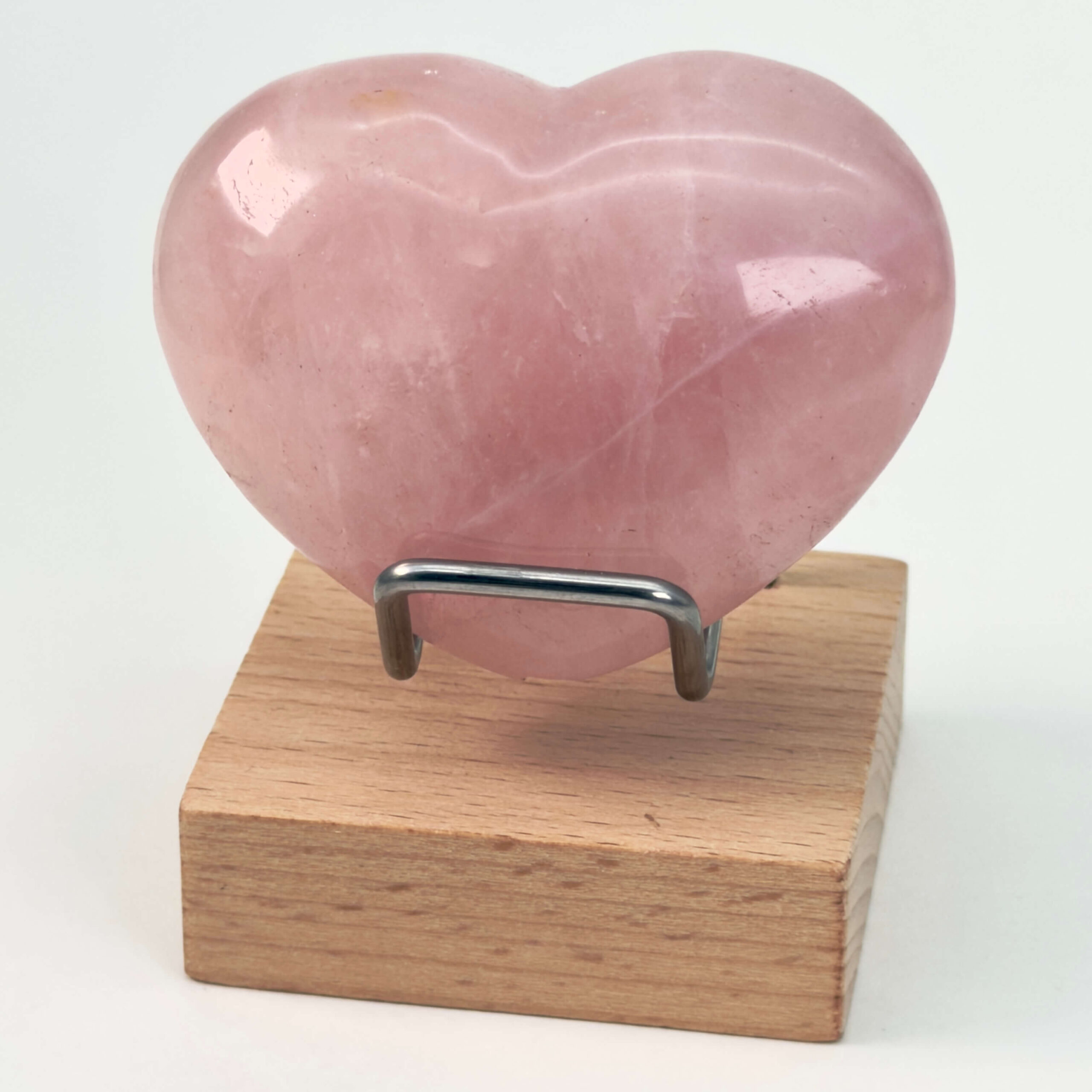 Rosakvarts Hjerte Krystal Sten på hvid baggrund på holder