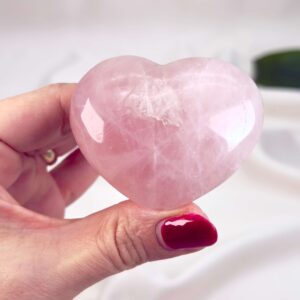 Rosakvarts Hjerte Krystal Sten på hvid baggrund i hånd