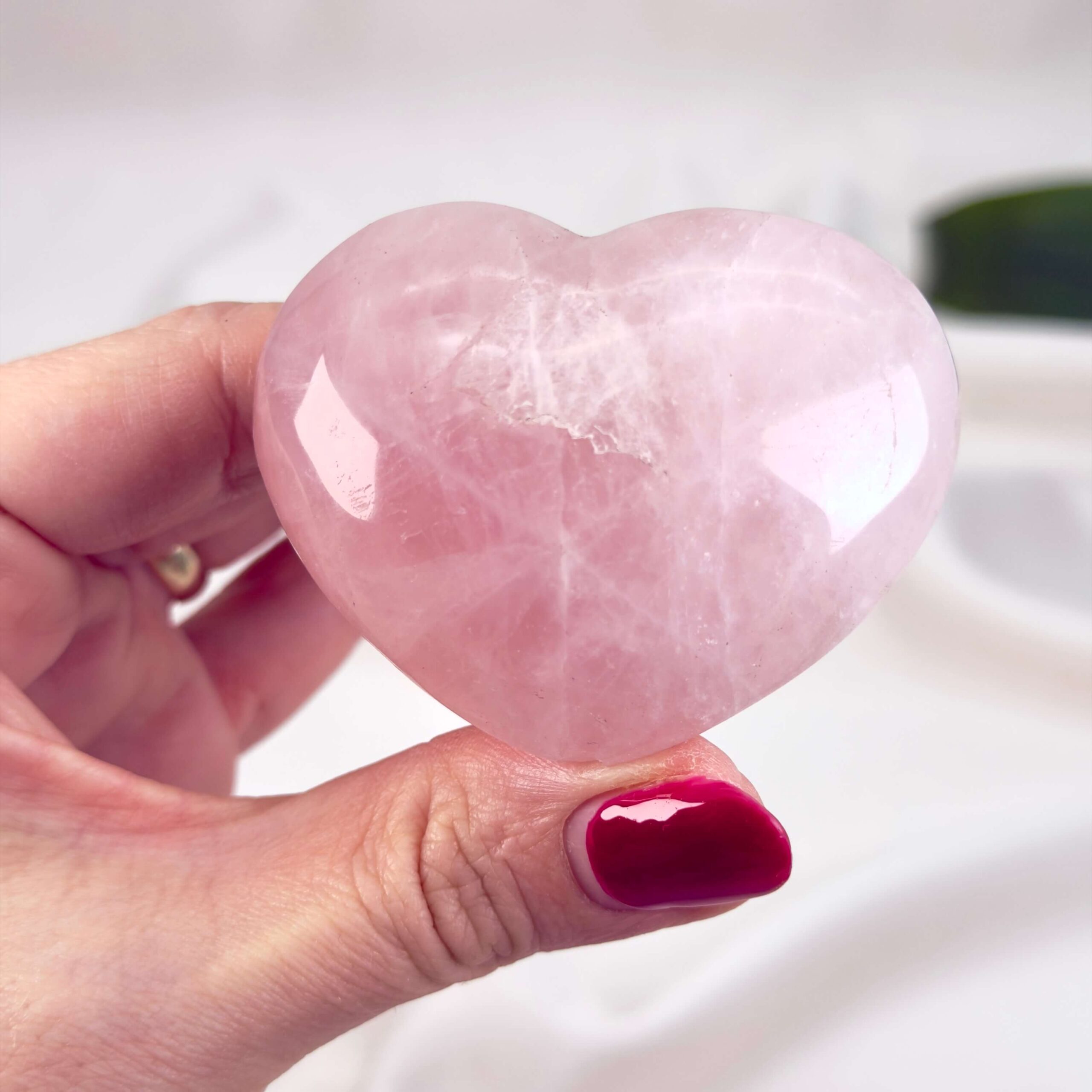 Rosakvarts Hjerte Krystal Sten på hvid baggrund i hånd
