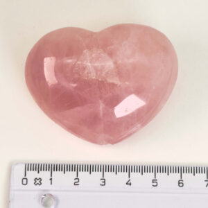 Rosakvarts Hjerte Krystal Sten på hvid baggrund med lineal