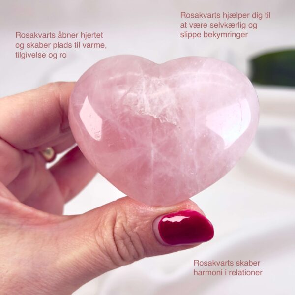 Rosakvarts Hjerte Krystal Sten på hvid baggrund i hånd med tags