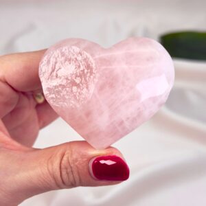 Rosakvarts Hjerte Krystal Sten på hvid baggrund i hånd