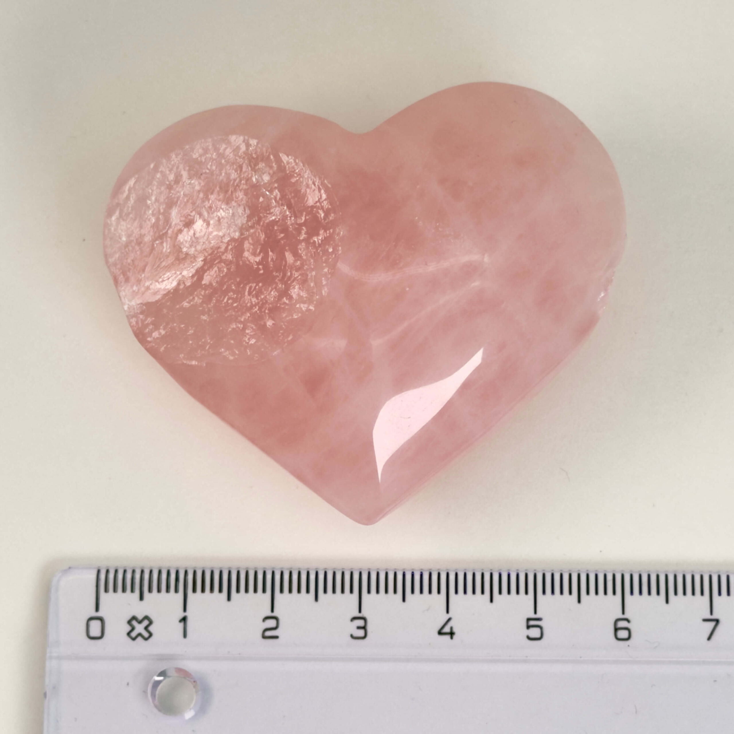 Rosakvarts Hjerte Krystal Sten på hvid baggrund med lineal