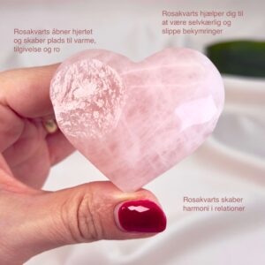 Rosakvarts Hjerte Krystal Sten på hvid baggrund i hånd med tags