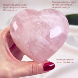 Rosakvarts Hjerte Krystal Sten på hvid baggrund i hånd med tags