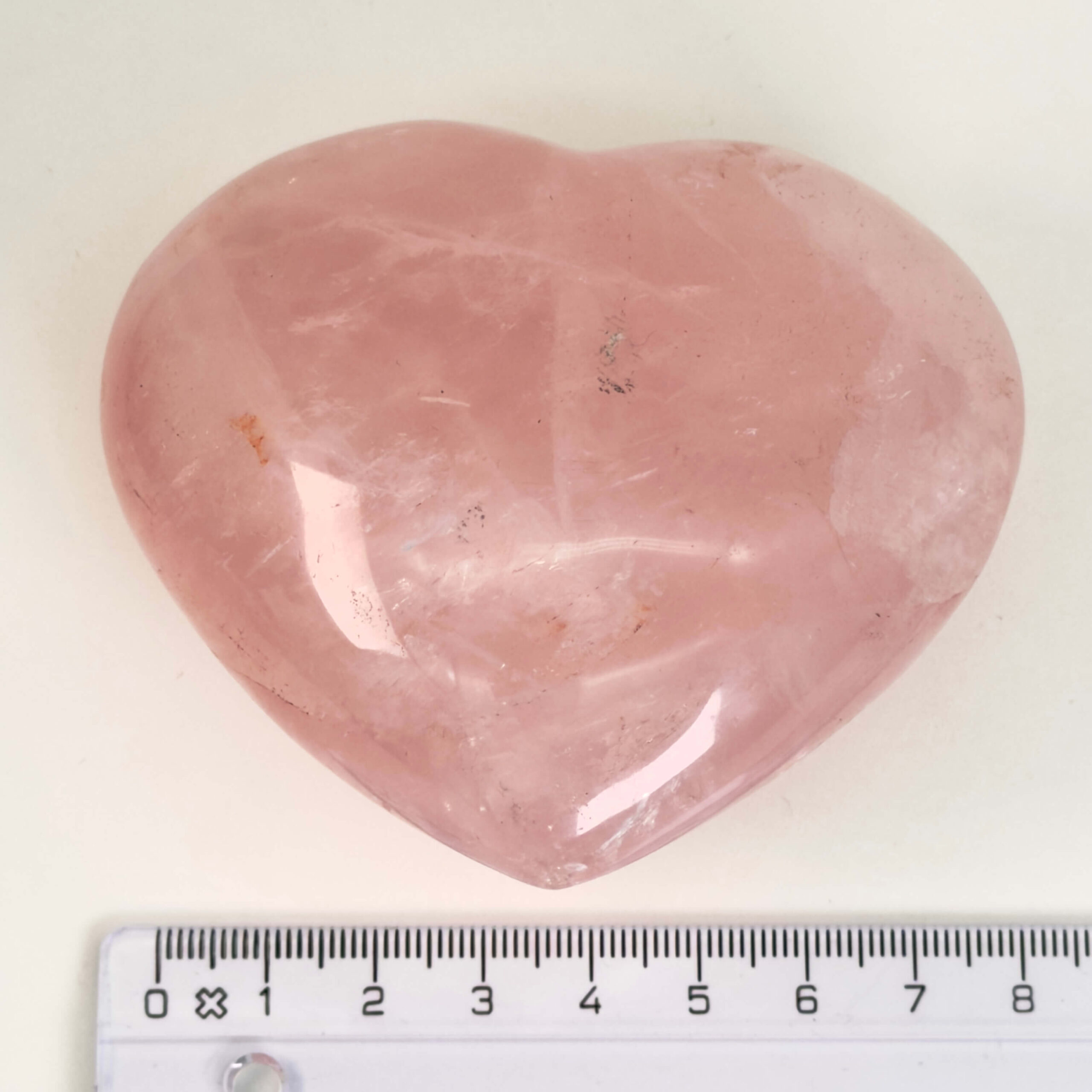 Rosakvarts Hjerte Krystal Sten på hvid baggrund med lineal