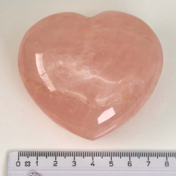 Rosakvarts Hjerte Krystal Sten på hvid baggrund med lineal